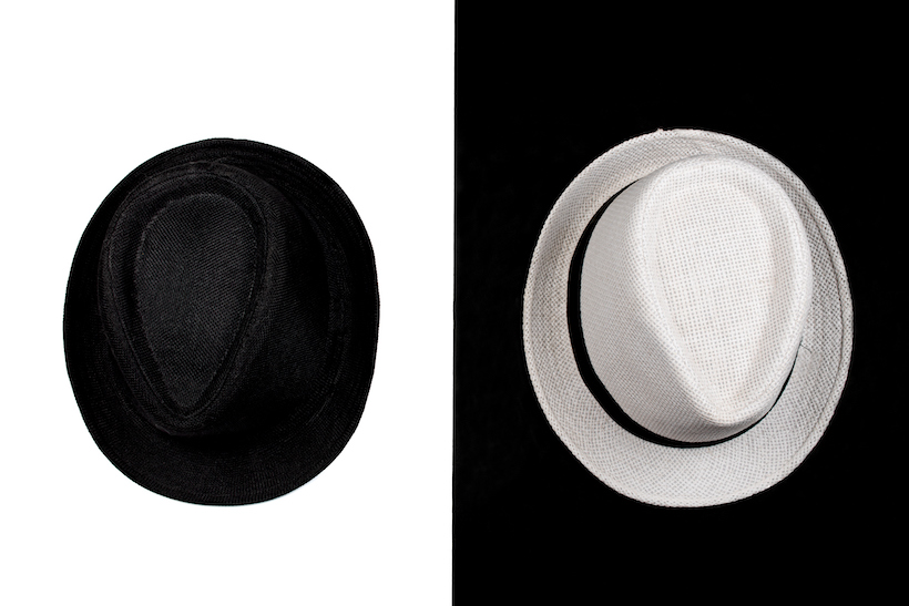 Black and white fedora hats on contrasting background